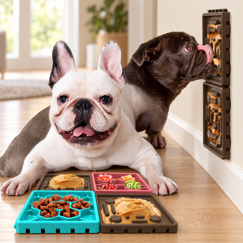 Two French bulldogs beside Brighty Calm tricolour chocolate lick mats, with food-filled floor panels and two chocolate-brown panels mounted on the wall.