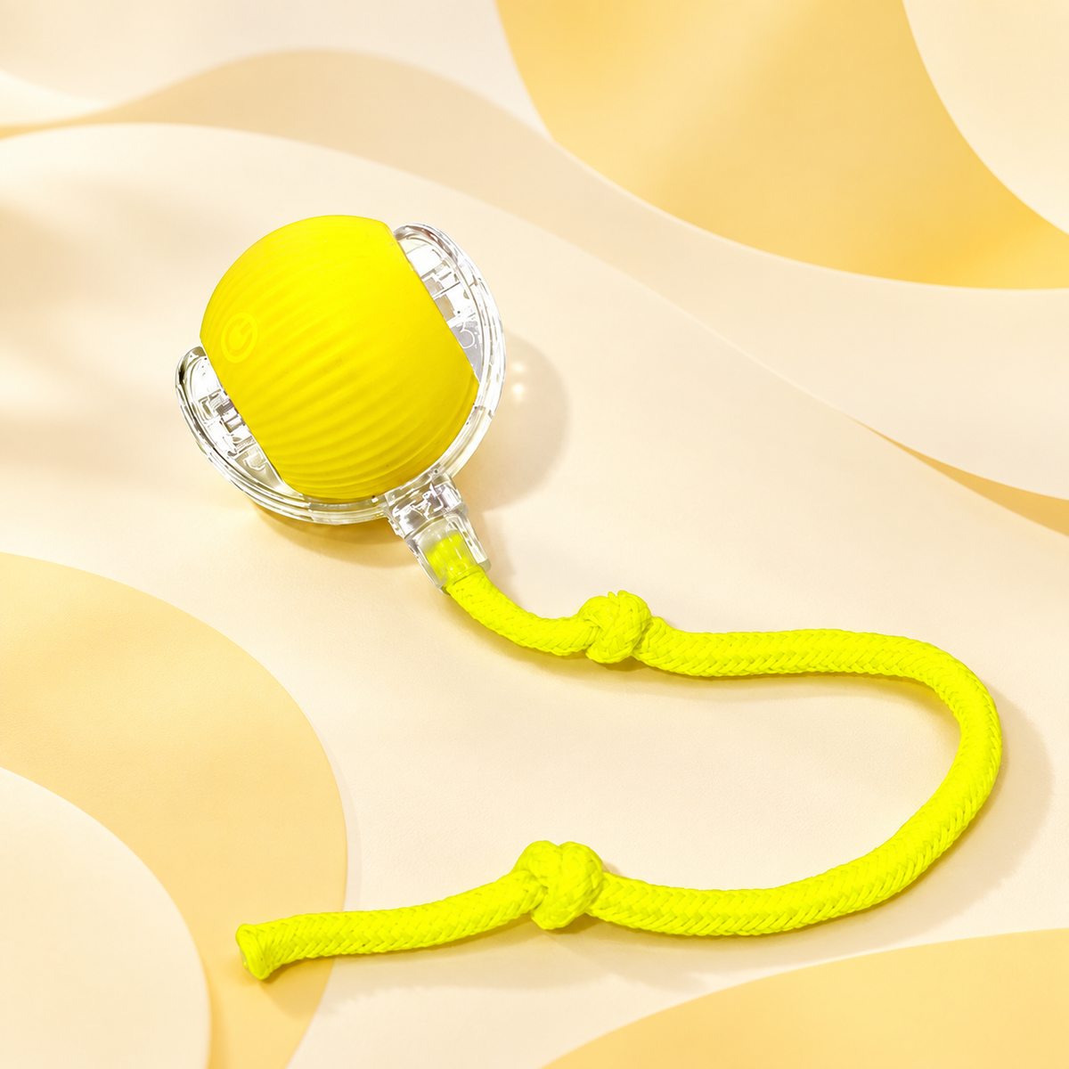 Yellow Brighty MotionBall with a ribbed surface, transparent outer frame and matching knotted rope, displayed against a soft yellow background.