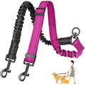 Pink and black elastic double dog leash coupler with adjustable straps, metal clips and a diagram of two dogs being walked.